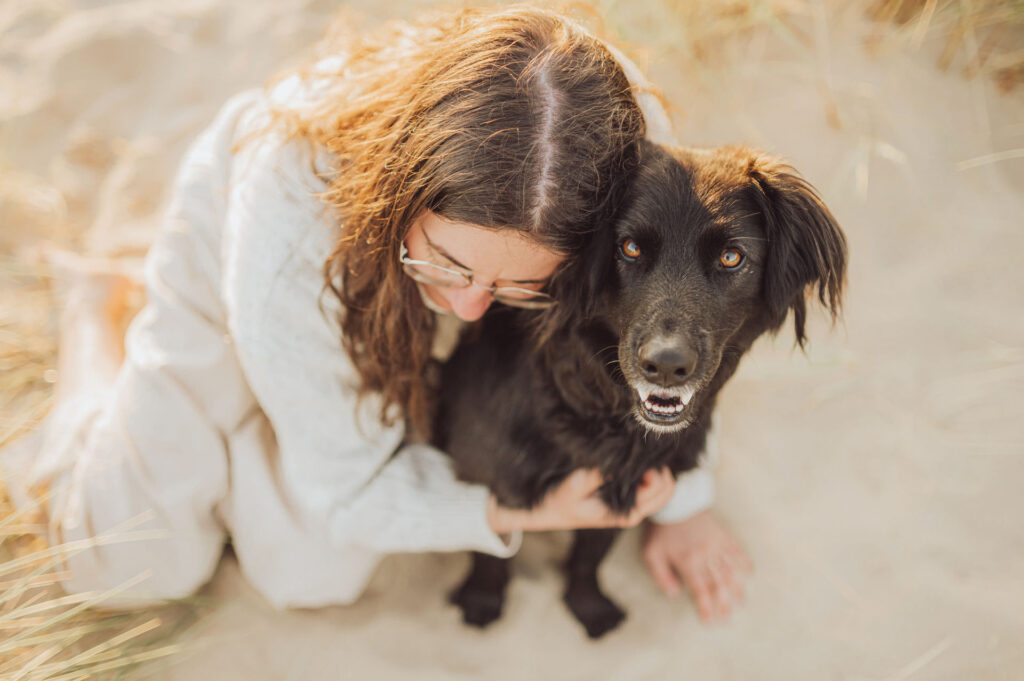 Fotoshooting mit Hund in Holland 15 Sarah hält ihren Hund am Strand – berührendes Strandshooting Holland