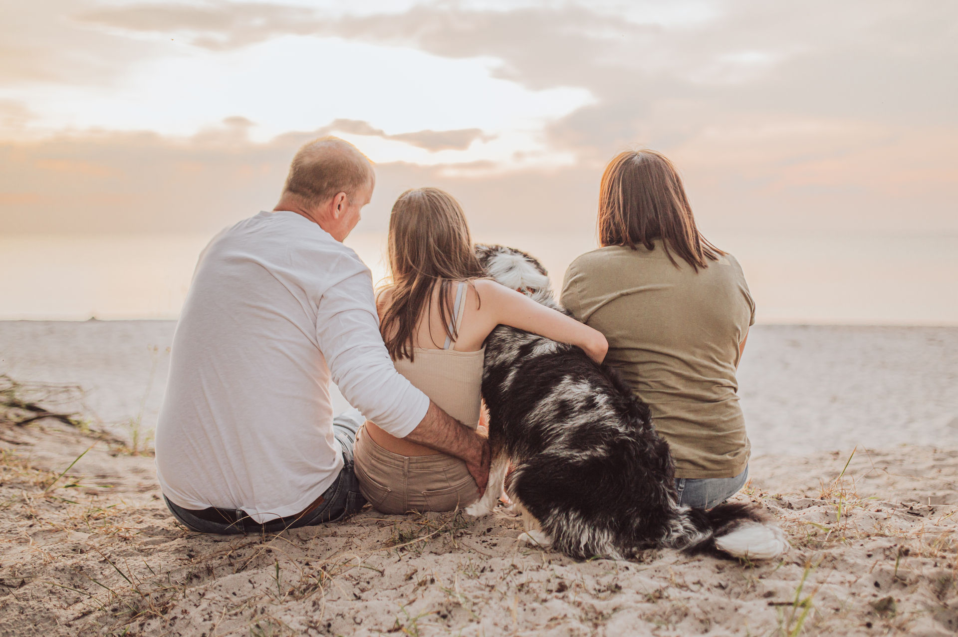 Familienfotoshooting mit Hund am Strand Familie schaut aufs Meer von hinten Sonnenuntergang Ostseestrand Graal-Mueritz Familienshooting